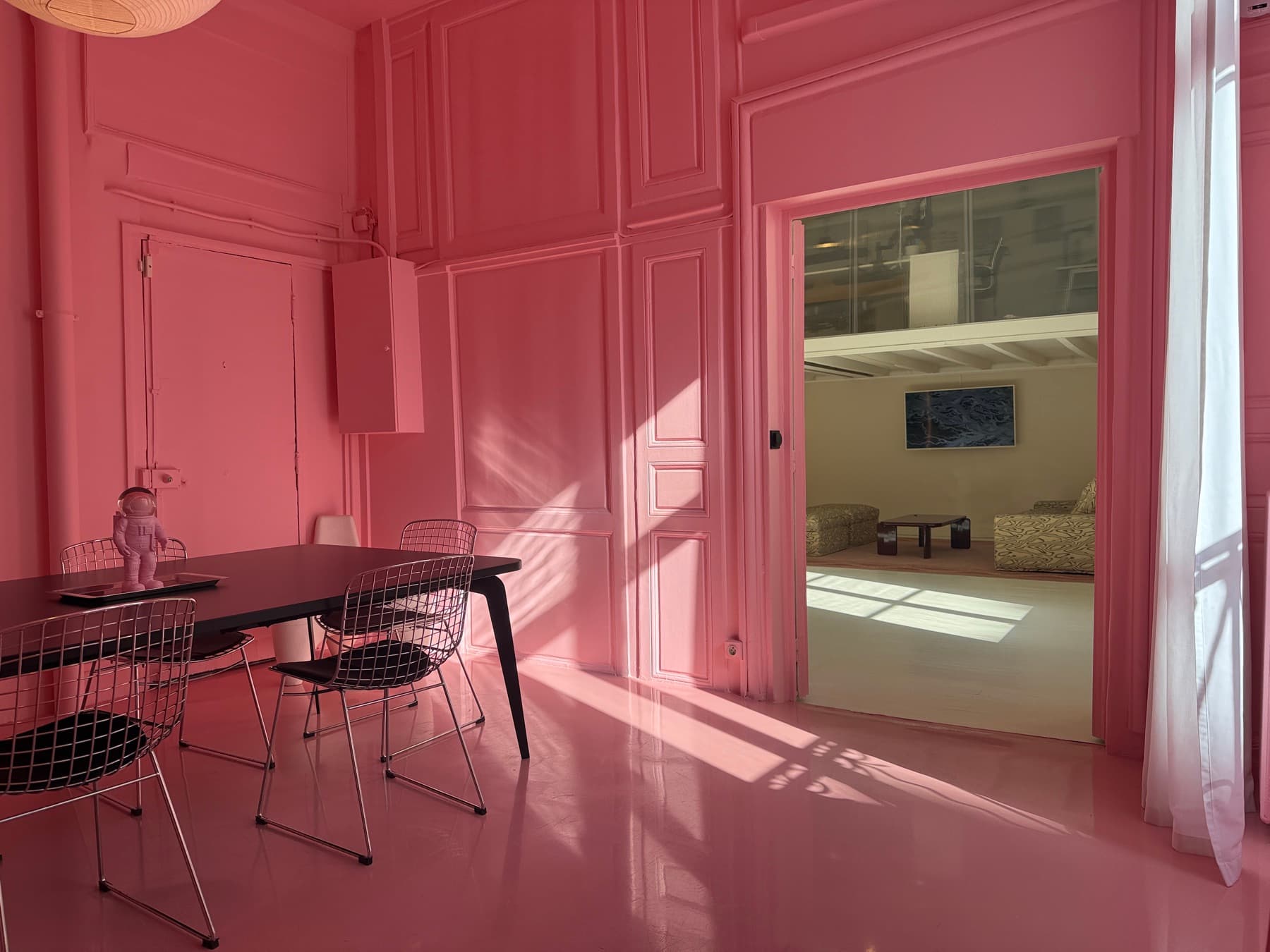 Pink room with astronaut figurine, opening to the main space — Chez Les Plombiers