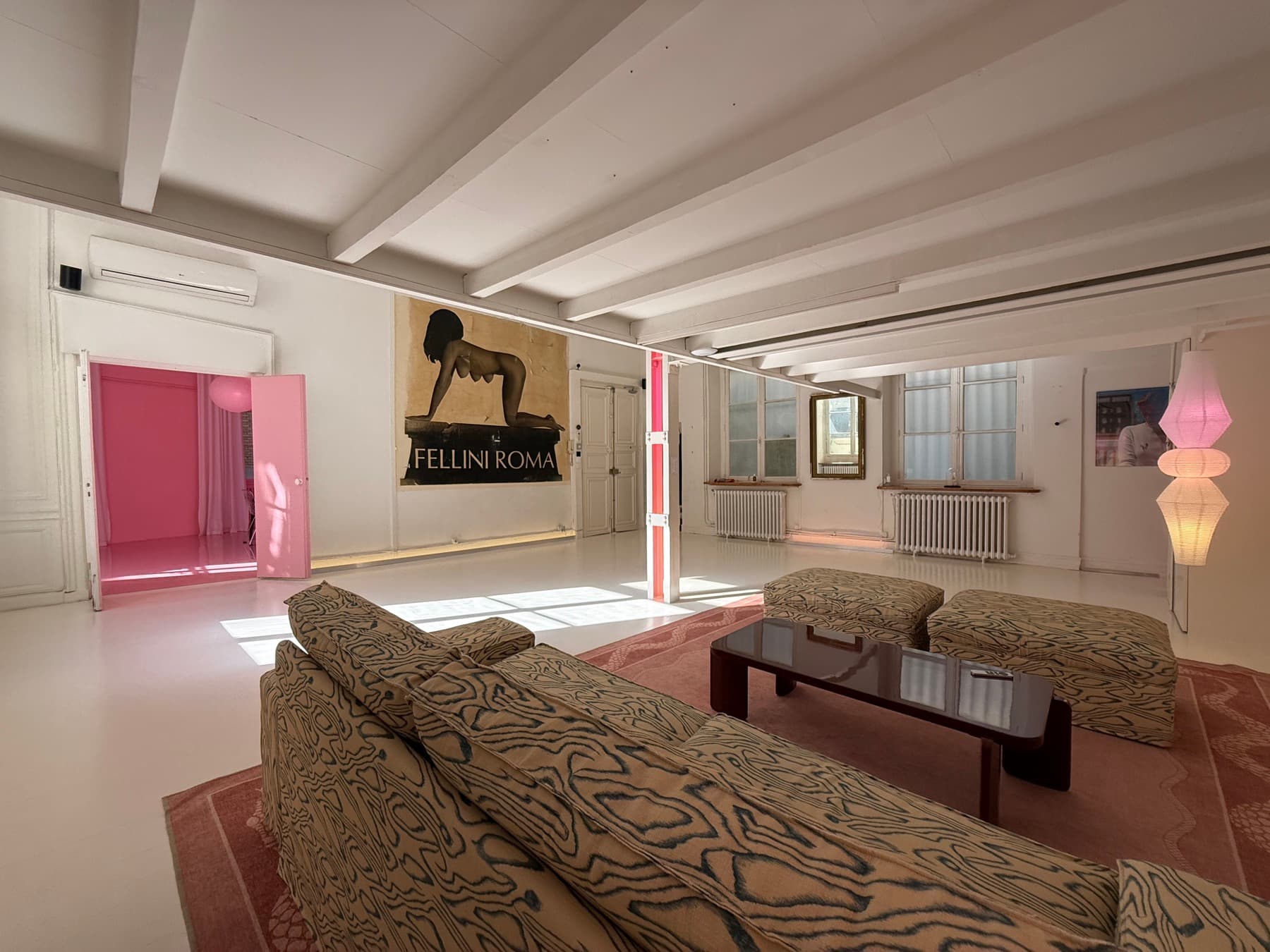 Wide view of the main lounge — designer furniture, white beams and air conditioning