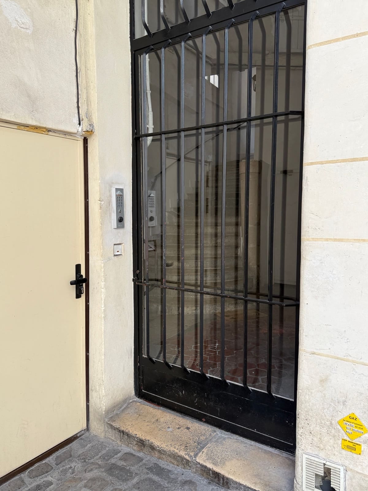 La porte de l'immeuble dans la cour, avec son digicode, qui mène à L'Appartement